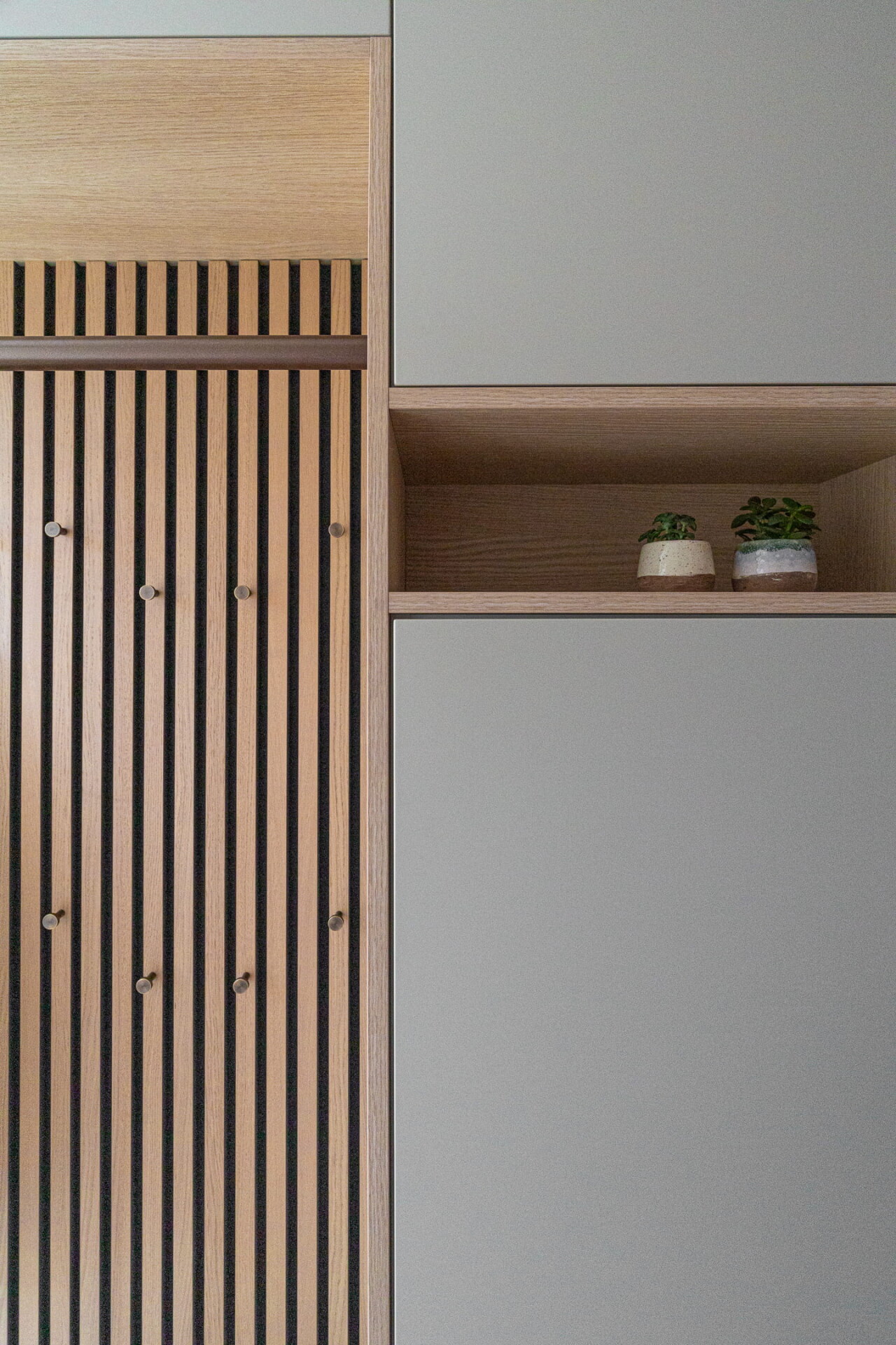 maatwerk kast met kapstokhaakjes op latenwand met opbergruimte