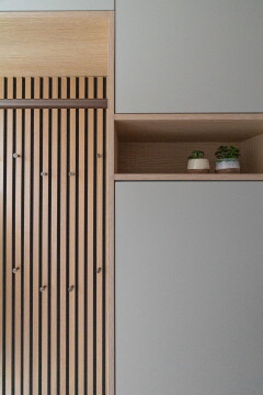 maatwerk kast met kapstokhaakjes op latenwand met opbergruimte