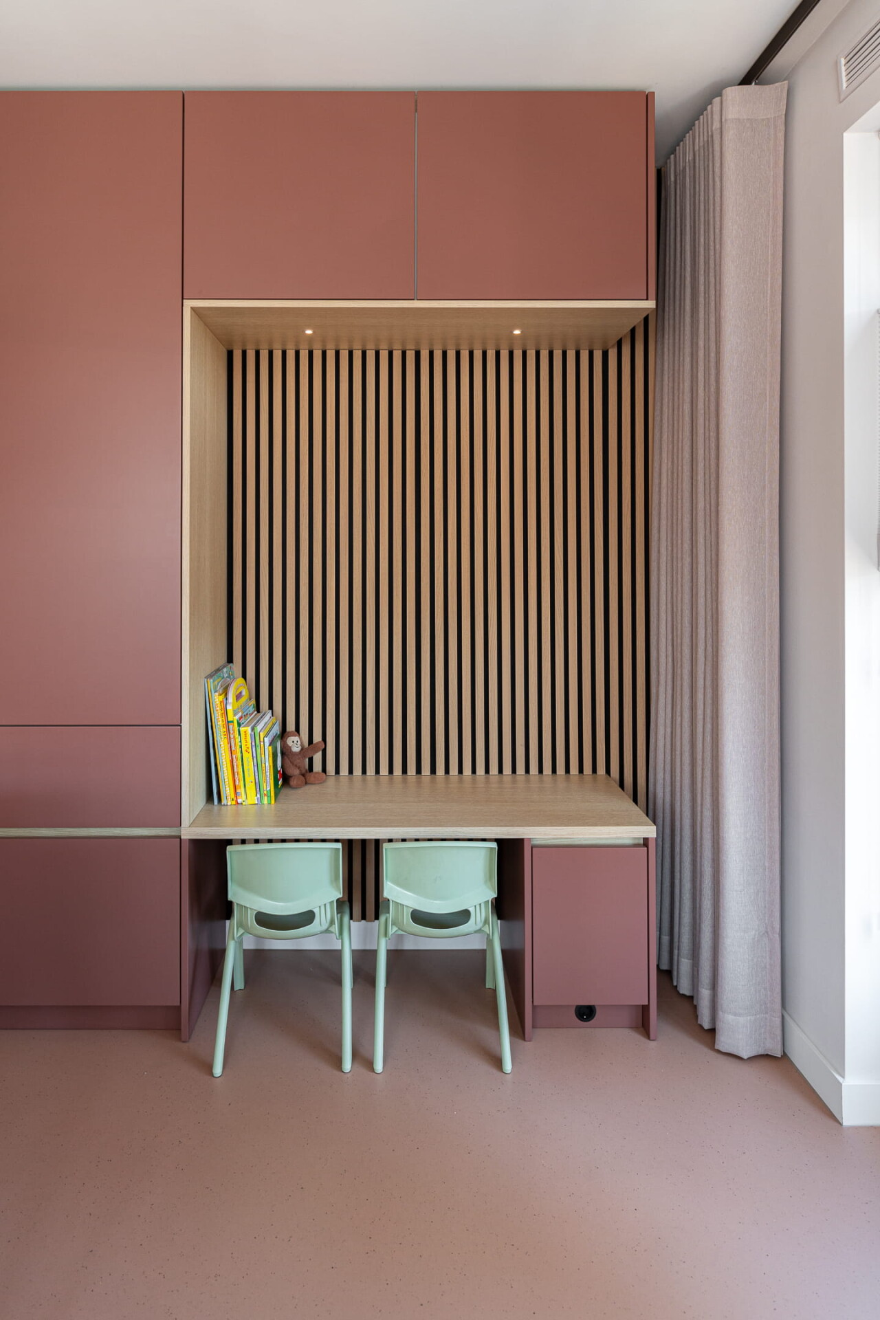 maatwerk kast met nis met eiken houten latten en bureau voor de kinderen met blauwe stoelen