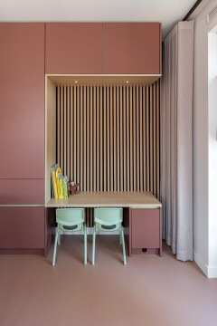 maatwerk kast met nis met eiken houten latten en bureau voor de kinderen met blauwe stoelen