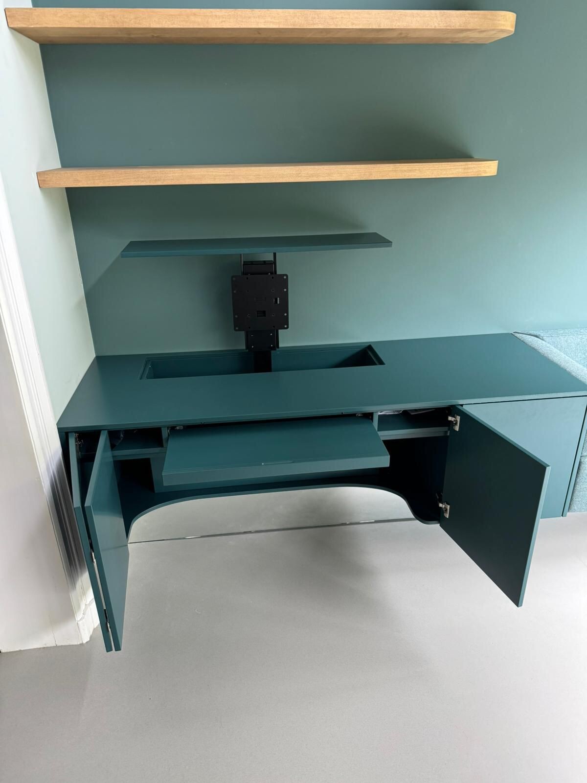 blad uitschuifbaar van bureau en scharnieren in blauwe kastdeuren.