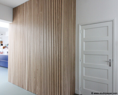 Wand met verticale eiken latten als stijlvolle scheiding in interieur Amersfoort