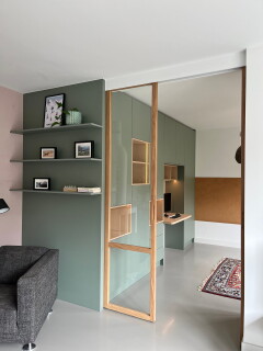 Schuifdeuren van hout met glas en ingefreesde handgrepen die de woonkamer kunnen opdelen en een werkplek cre&euml;ren.