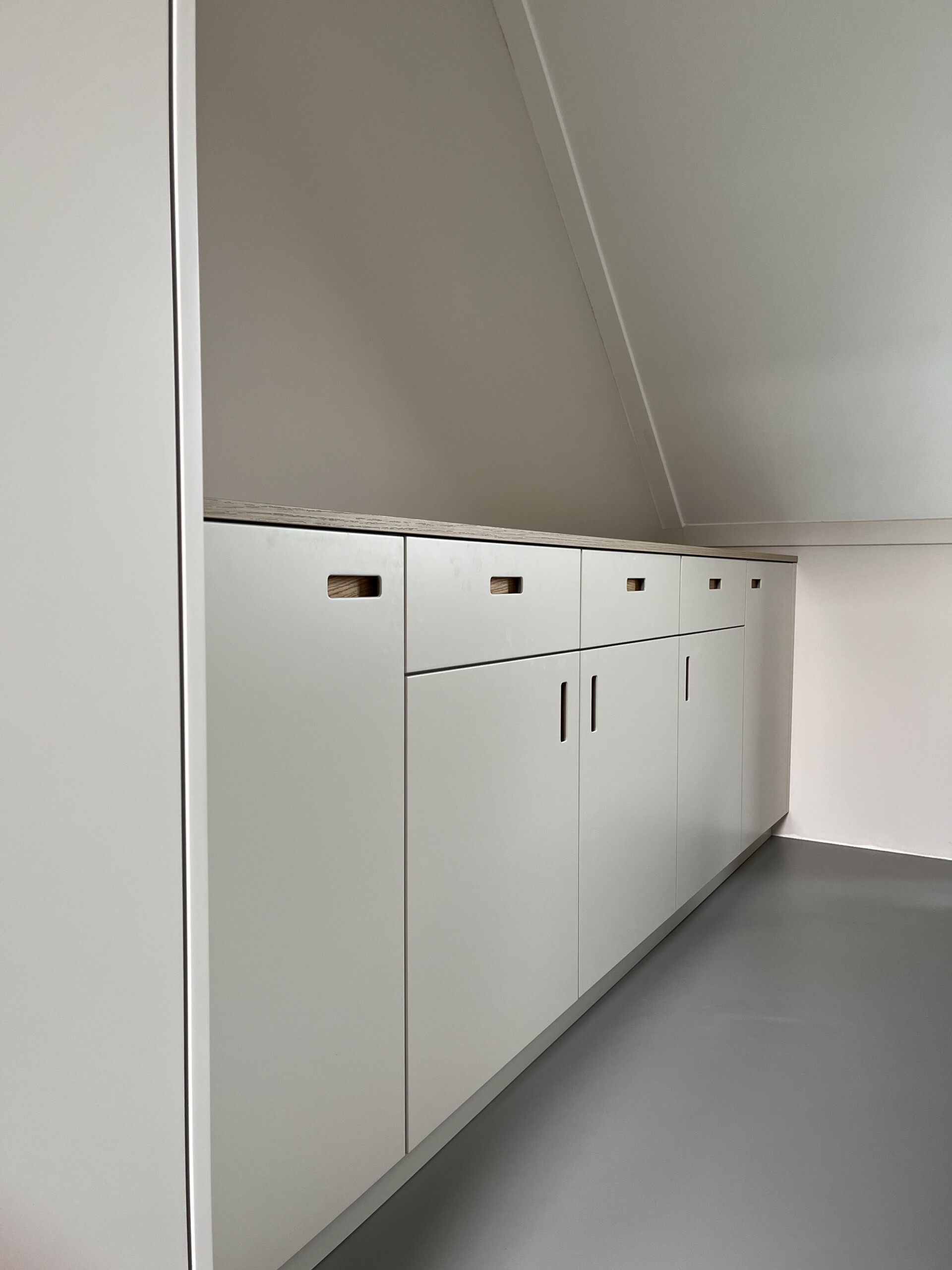 Volledige kastwand op maat in slaapkamer met plafondhoge afwerking en opbergruimte
