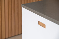 Detail van wit keukenfront met eiken accenten en strakke belijning