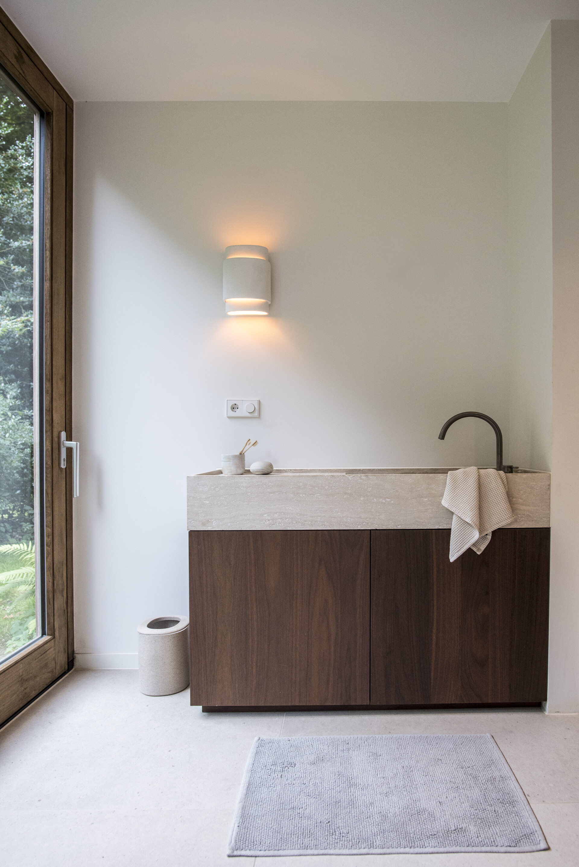 Minimalistische badkamer met walnoot en travertin