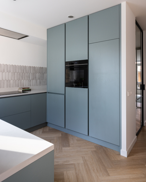 keuken blauw met kastenwand van vloer tot plafond en oven in het midden