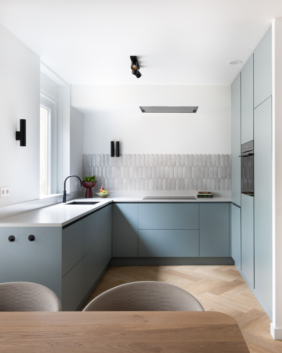 minimalitische keuken met royale lichtinval en zwarte accessiores zoals kraan en lamparmatuur.