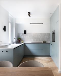 minimalitische keuken met royale lichtinval en zwarte accessiores zoals kraan en lamparmatuur.