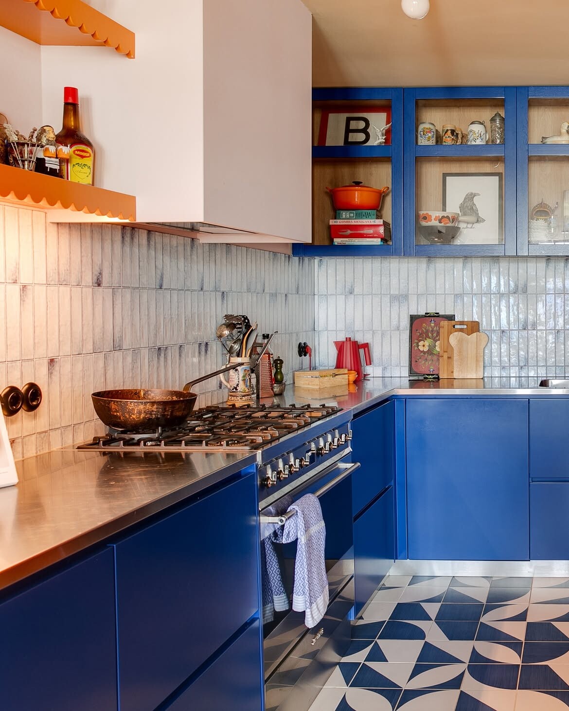 kleurrijk keuken ontwerp met blauwe fronten en oranje accenten