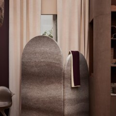 afronde roomdivider in grijstinten met beige gordijnen en bruine maatwerk kast