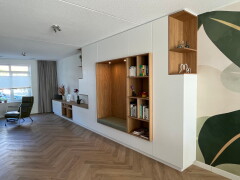 Wit wandmeubel van vloer tot plafond met open en gesloten opbergruimte